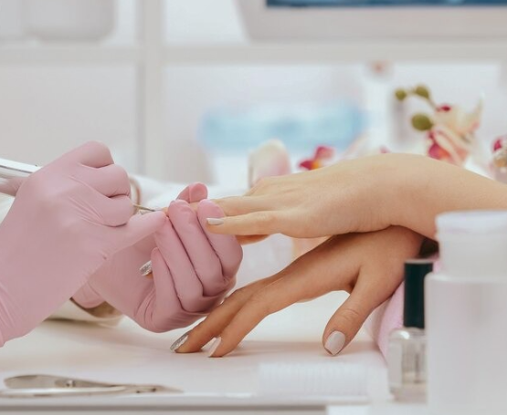 Manicurista realizando manicura semipermanente